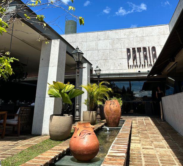 Entrada do Pátria, com espelho d'água e vasos de cerâmica