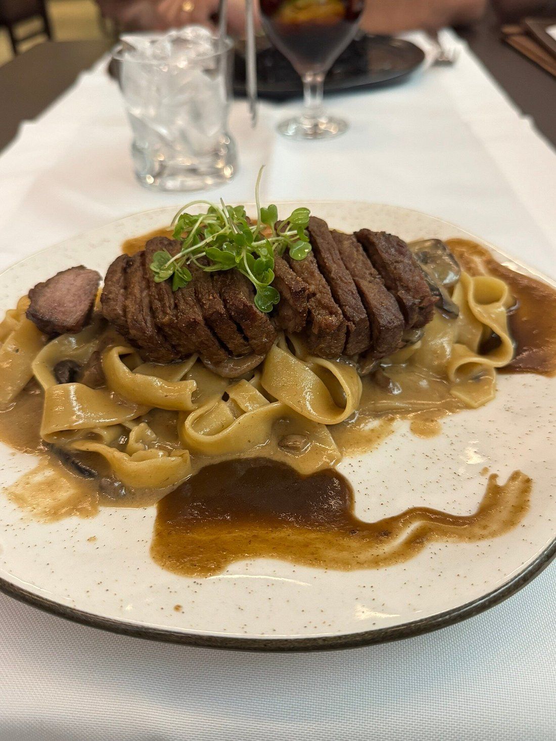 Carne fatiada sobre massa com molho